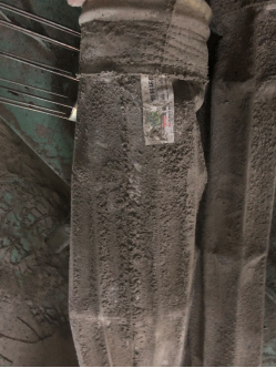 Actual filter bag with heavy moisture-affected dust caking