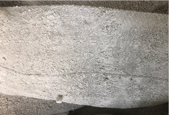 Comparable dense surface caking on a cement baghouse filter bag