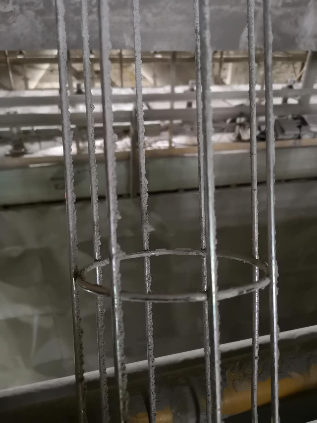 Actual filter cage with hardened dust deposits on the wires